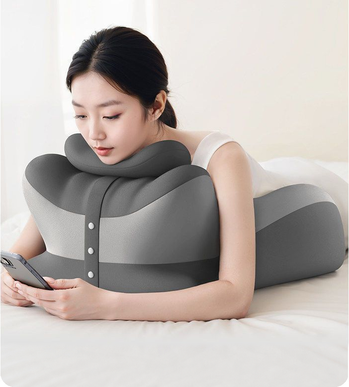 うつ伏せでスマートフォンを操作しながらサポート枕を使用している場面